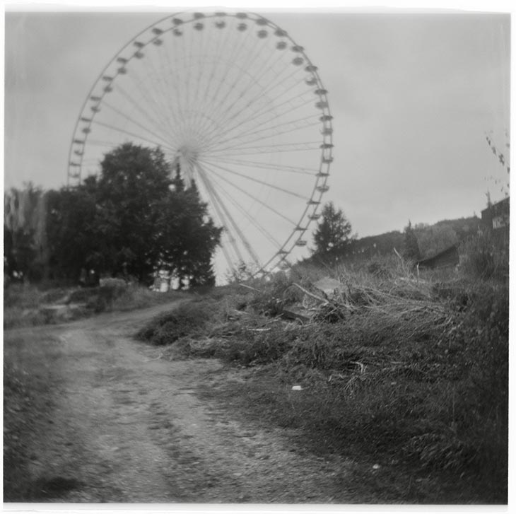 ein Feldweg mit Riesenrad im Hintergrund mit der Pouva Start fotografiert